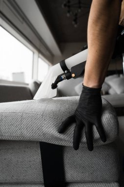 Ekstraktör temizliği evdeki koltuğun tozunu alıyor. Döşeme mobilyalarının liflerini sökücüyle kuru temizleme.