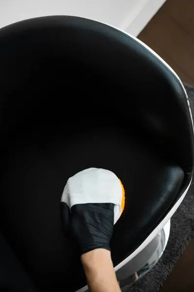 stock image Dealing with stains and dust on leather furniture using brush and foam. Cleaning dark leather chair with a soft brush and detergent