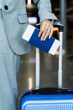 Bagajlı kız, elinde uçak biletleriyle pasaportunu tutuyor. Seyahatten önce bavullu bir iş kadını bavuluna göz kulak oluyor. Tatil ve seyahat kavramı