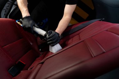 Elektrikli süpürge kullanarak oto koltuğu detaylandırılıyor. Özel süpürge hortumunun yardımıyla araba koltuğundan kir kaldırılıyor.