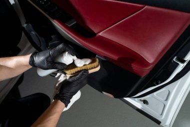 Otomobil kapısındaki toz ve kiri temizleme işlemi. Araba temizleyicisi otomatik kapıyı fırça ve deterjanla temizliyor.