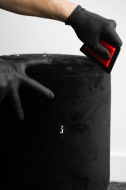 Döşeme fırçasını kirli mobilyaları ve evcil hayvan ayak izlerini kurutmak için kullanıyor. Temizlikçi, kürk fırçasıyla koltuktan köpek tüylerini alıyor.