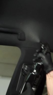 4K dikey videoda ana başlığa deterjan sıkıyorum. El, arabanın tavanını deterjan ve mikrofiber halıyla temizliyor. Ayrıntılı araba ana başlığı korunuyor