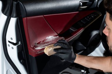 Araba temizleyicisi araba kapısını fırça ve deterjanla temizler. Otomatik kapı panelinden toz ve kir kaldırma işlemi
