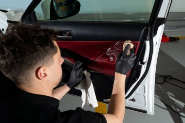 Sabunlu bir fırçayla arabanın kapısını temizleyen siyah bir eldiven verin. Ayrıntılı prosedür. Arabanın kapı panelini deterjanla temizleme işlemi