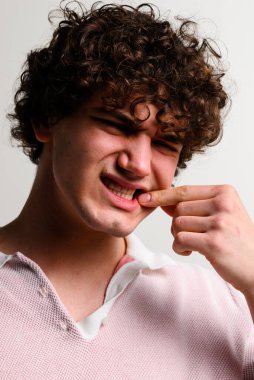 Zayıf hijyen, insanın dişlerinin etrafında ciddi şekilde iltihaplanmış yumuşak dokulara yol açtı. Diş eti hastalığıyla uğraşıyor. Periodontit kaynaklı diş ağrısı çekiyor.