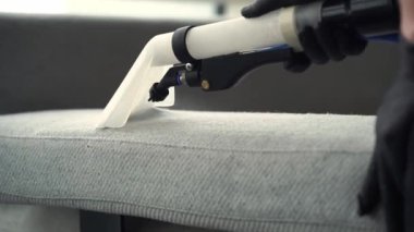 Ekstraktör temizliği 4K videosundaki koltuğun tozunu alıyor. Döşeme mobilyalarının liflerini sökücüyle kuru temizleme.