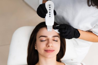 Yüzünde ölü derinin özel ultrason donanımı ile dezenfekte edilmesi. Kozmetoloji kliniğinde mağara soyma işlemi