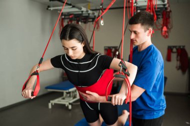 Rehabilitasyon merkezinde denetimli kırmızı kordon fizyoterapisi. Spor sakatlığının ağrısız kırmızı kablo tedavisi. Nöromüsküler sistem kırmızı kablo ekipmanıyla etkinleştiriliyor