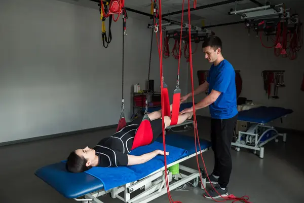 stock image Red cord rehabilitation to recover from muscle pain. Activation of back muscles after injury with sling system red cord