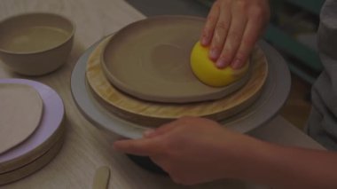 Çömlek sınıfı 4K video için sünger kullanmak. Aşırı nemden kurtulmak için sünger emiyor. Kil ürünlerine daha fazla nem uygulamak. Süngerle kil yumuşatmak. Seramik atölyesi.