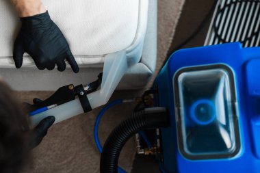 Temizlikçi evdeki yatak yatağını temizlemek için sökücü kullanıyor. Kanepenin liflerindeki kiri sökücüyle emmek. Yatak kuru temizleme makinesini kullanarak.