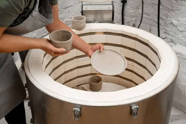 Stock image Placing pottery in a muffle furnace to heat it to high temperatures. The process of firing clay products