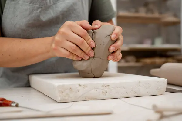 stock image Removing air bubbles from clay before modeling to avoid the ruination of a ceramic product. Wedging the clay before starting making a pottery project to create proper consistency