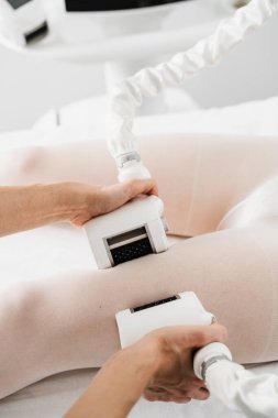 Lenfatik drenaj işlemi. Doktor lenf bezlerindeki tıkanıklığı tedavi etmek için lenfatik drenaj kullanıyor. Genç bir kadın, makina güdümlü lenfatik drenaj prosedürü geçiriyor.