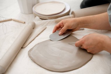 Removing air bubbles from clay before hand building. Preventing clay bodies from cracks by wedging. Making pliable clay without air pockets clipart