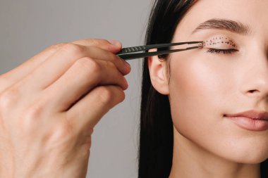 Tıbbi klinikteki yüz bölgesini değiştiren estetik ameliyattan önce yüzünde Blepharoplasti izi var. 2 doktor estetik ameliyat yapıyor.