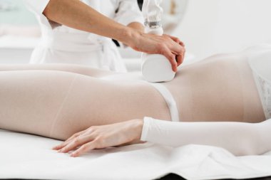 Doktor lenf bezlerindeki tıkanıklığı tedavi etmek için lenfatik drenaj kullanıyor. Lenfatik drenaj işlemi. Genç bir kadın, makina güdümlü lenfatik drenaj prosedürü geçiriyor.