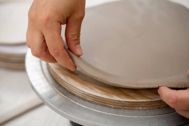 Keskin bir çömlek bıçağı kullanarak kilden mükemmel yuvarlak bir şekil çıkarmışlar. Seramik dersi. Çamuru yuvarlak bir forma modellemek