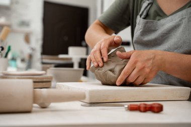 Wedging the clay before starting making a pottery project to create proper consistency. Removing air bubbles from clay before modeling to avoid the ruination of a ceramic product clipart