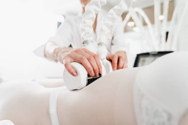 Doktor lenf bezlerindeki tıkanıklığı tedavi etmek için lenfatik drenaj kullanıyor. Lenfatik drenaj işlemi. Genç bir kadın, makina güdümlü lenfatik drenaj prosedürü geçiriyor.