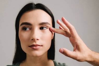 Göz kapakları, göz torbalarını çıkarmak ve yaşlanmayla başa çıkmak için birofaroplasti ameliyatı oluyor. BlePharoplasti. Kadın ameliyat sonrası kanamayı önlemek ve cerrahi müdahaleyi gizlemek için bandaj yaptırıyor.