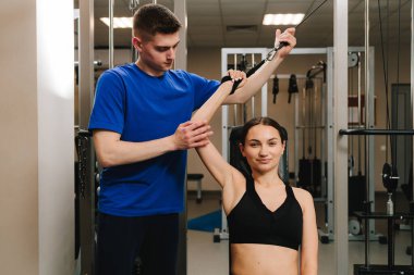 Genç kız, kol yaralanması üstüne rehabilitasyona hazırlanmak için kinezi tedavisi görüyor. Terapi jimnastiğiyle fiziksel yetersizliği ortadan kaldırmak. El hareketliliği geri yükleniyor