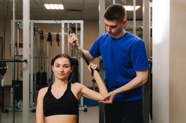 Terapi jimnastiğiyle fiziksel yetersizliği ortadan kaldırmak. El hareketliliğini düzeltiyorum. Genç kız, kol yaralanması sonrası rehabilitasyona hazırlanmak için kinezi tedavisi görüyor.