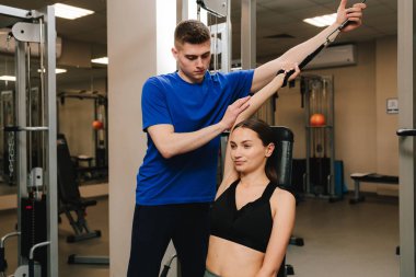 Terapi jimnastiğiyle fiziksel yetersizliği ortadan kaldırmak. El hareketliliğini düzeltiyorum. Genç kız, kol yaralanması sonrası rehabilitasyona hazırlanmak için kinezi tedavisi görüyor.