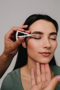 Üst blefaroplasti. Plastik cerrah, Castroviejo kalibresini kullanarak hastasının gözünün içindeki cerrahi mesafeyi ölçüyor. Göz kapaklarını düzeltmek için biofaroplasti hazırlanıyor.
