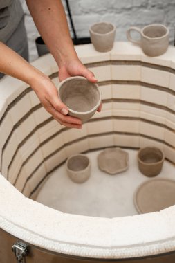 Yüksek sıcaklıklarda ısıtmak için çömlek fırınına koymak. Kil ürünleri ateşleme süreci