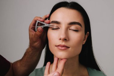 Üst blefaroplasti. Plastik cerrah, Castroviejo kalibresini kullanarak hastasının gözünün içindeki cerrahi mesafeyi ölçüyor. Göz kapaklarını düzeltmek için biofaroplasti hazırlanıyor.