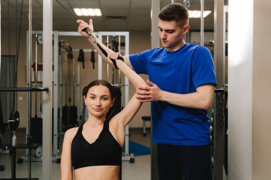 Terapi jimnastiğiyle fiziksel yetersizliği ortadan kaldırmak. El hareketliliğini düzeltiyorum. Genç kız, kol yaralanması sonrası rehabilitasyona hazırlanmak için kinezi tedavisi görüyor.