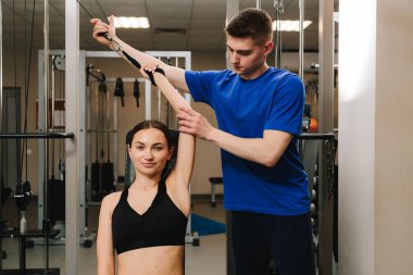 Terapi jimnastiğiyle fiziksel yetersizliği ortadan kaldırmak. El hareketliliğini düzeltiyorum. Genç kız, kol yaralanması sonrası rehabilitasyona hazırlanmak için kinezi tedavisi görüyor.