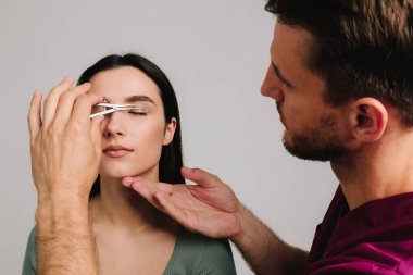 Plastik cerrah, Castroviejo kalibresini kullanarak hastasının gözünün içindeki cerrahi mesafeyi ölçüyor. Göz kapaklarını düzeltmek için birofaroplasti hazırlıyorum. Üst blefaroplasti.