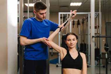 Genç kız, kol yaralanması üstüne rehabilitasyona hazırlanmak için kinezi tedavisi görüyor. Terapi jimnastiğiyle fiziksel yetersizliği ortadan kaldırmak. El hareketliliği geri yükleniyor