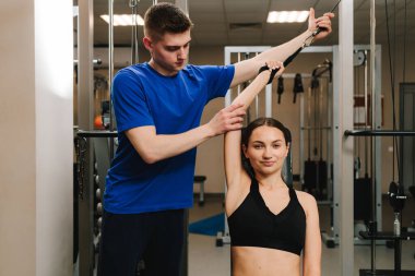 Genç kız, kol yaralanması üstüne rehabilitasyona hazırlanmak için kinezi tedavisi görüyor. Terapi jimnastiğiyle fiziksel yetersizliği ortadan kaldırmak. El hareketliliği geri yükleniyor