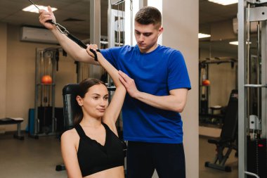 Genç kız, kol yaralanması üstüne rehabilitasyona hazırlanmak için kinezi tedavisi görüyor. Terapi jimnastiğiyle fiziksel yetersizliği ortadan kaldırmak. El hareketliliği geri yükleniyor