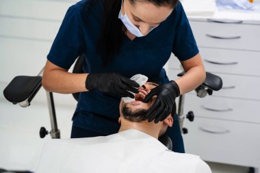 Dudak retraktörü yükleme işlemi. Diş kliniğinde dudak retraktörü kullanılarak stomatoloji tedavisine hazırlık