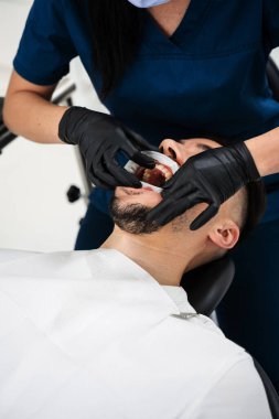 Dudak retraktörü yükleme işlemi. Diş kliniğinde dudak retraktörü kullanılarak stomatoloji tedavisine hazırlık