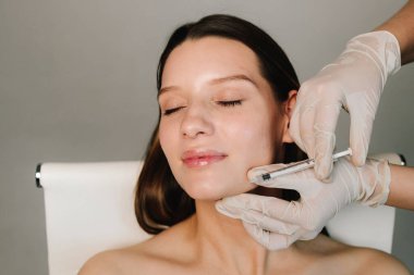 Çenenin şeklini botulinum toksin enjeksiyonuyla düzeltmek için plastik. Güzel ve elastik yüz ve çene hatları için Botulinum toksin enjeksiyonu prosedürü