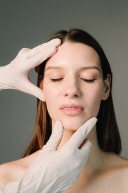 Yüz geliştirme. Yüzün şeklini düzeltmek için konturer plastik. Güzellik tedavisi için marka deri. Doktor kadın tenini güzel yüz hatlarına hazırlar..