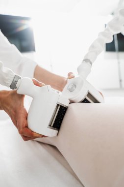 Genç bir kadın bacak şişliğini çıkarmak için lenfatik drenaj tedavisi görüyor. Atık ve toksinlerden kurtulmak için ritmik hareketleri ve masajı olan lenf sistemi hedefleniyor