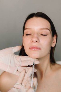 Çenenin şeklini botulinum toksin enjeksiyonuyla düzeltmek için plastik. Güzel ve elastik yüz ve çene hatları için Botulinum toksin enjeksiyonu prosedürü