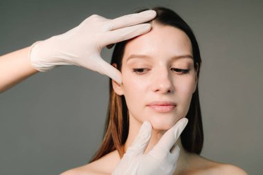 Yüz geliştirme. Yüzün şeklini düzeltmek için konturer plastik. Güzellik tedavisi için marka deri. Doktor kadın tenini güzel yüz hatlarına hazırlar..