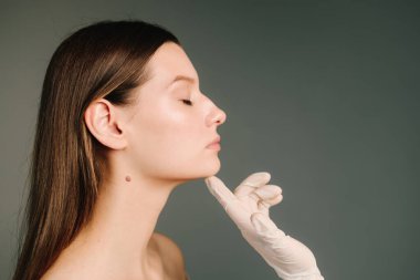 Yüz geliştirme. Yüzün şeklini düzeltmek için konturer plastik. Güzellik tedavisi için marka deri. Doktor kadın tenini güzel yüz hatlarına hazırlar..
