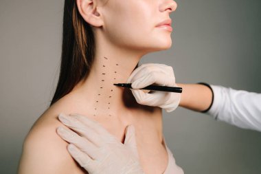 Nefertiti kaldırmadan önce işaretle. Kozmetik uzmanı bir kadının platizmasına botulinyum toksin enjekte edilmeden önce nokta çiziyor. Bir profesyonelden boyun geliştirme. Kadın estetik kozmetolojisi