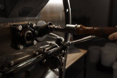 Kahve makinesinde kahve çekirdeği kızartıyorum. Tesiste kızarmış kahve taneleri var. Profesyonel kahve kızartma makinesi.