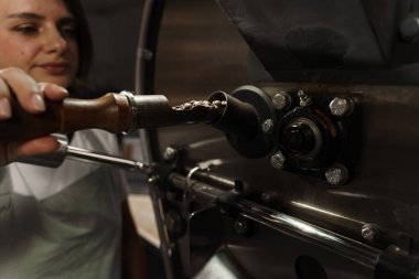 Tesiste kızarmış kahve taneleri var. Profesyonel kahve kızartma makinesi. Kahve makinesinde kahve çekirdeği kızartıyorum.