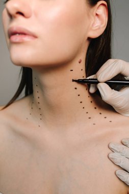 Nefertiti kaldırmadan önce işaretle. Kozmetik uzmanı bir kadının platizmasına botulinyum toksin enjekte edilmeden önce nokta çiziyor. Bir profesyonelden boyun geliştirme. Kadın estetik kozmetolojisi